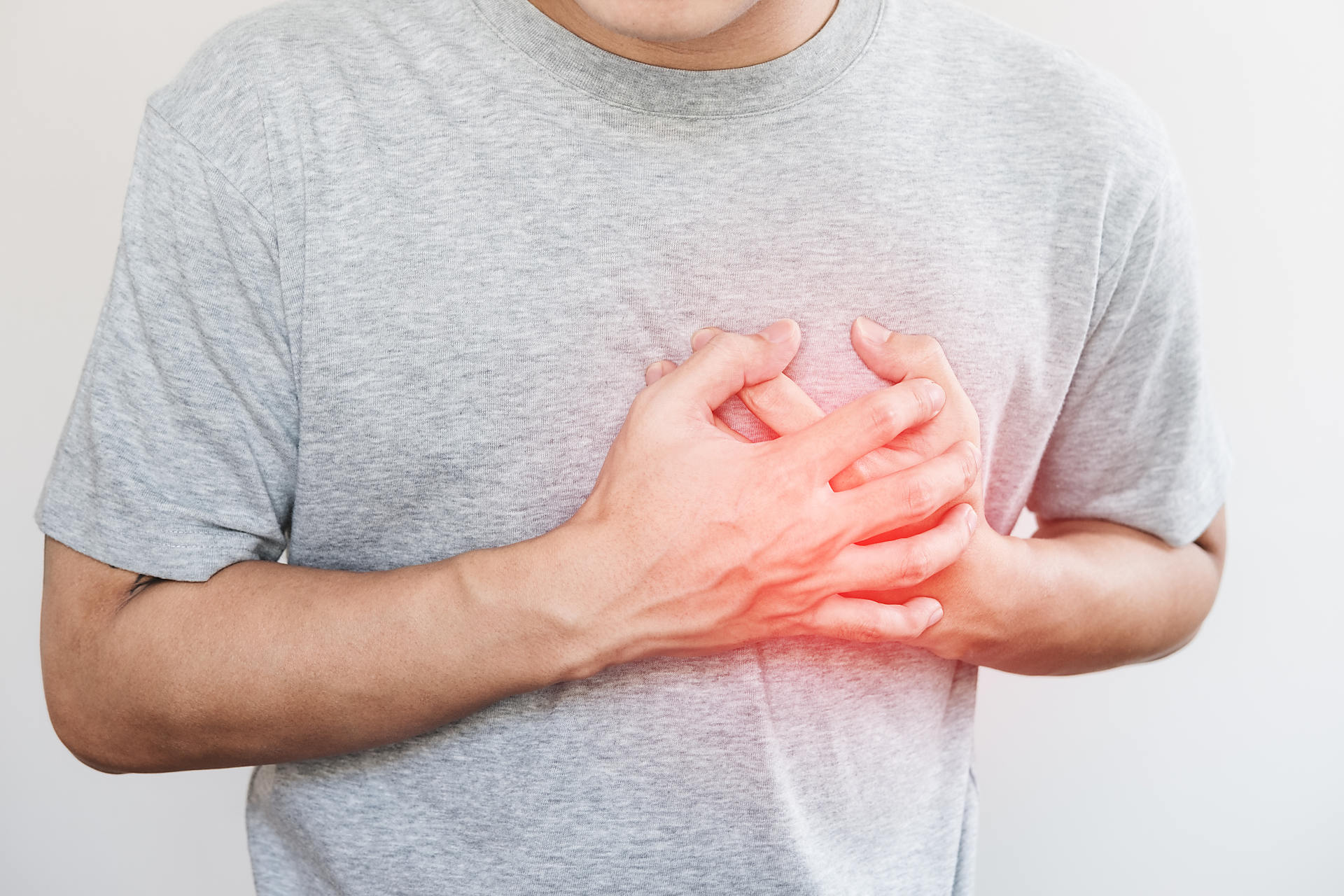心臓を押さえる人の画像
