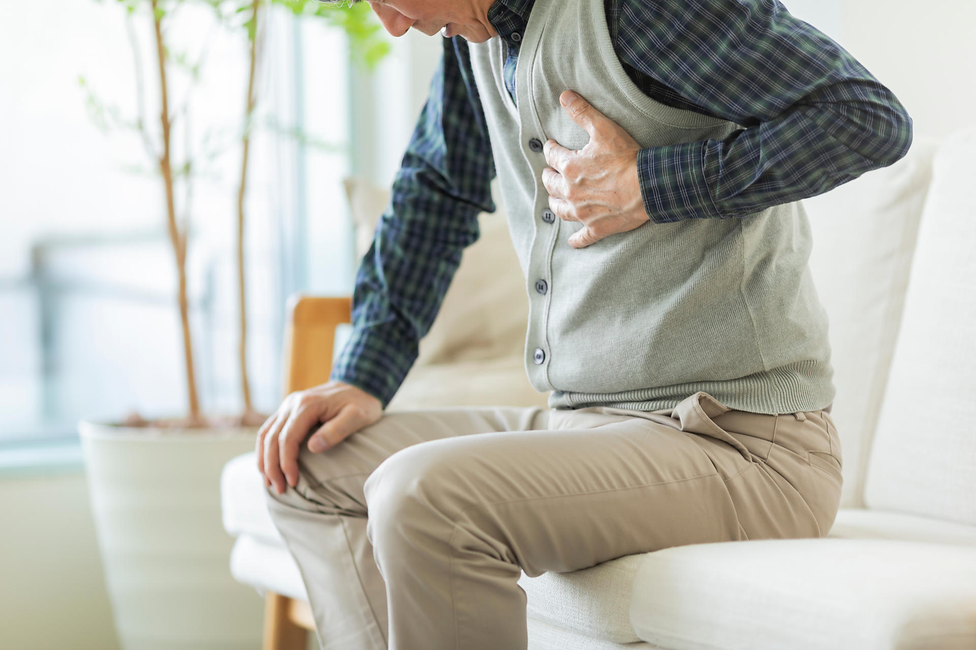 心臓を押さえる人の画像