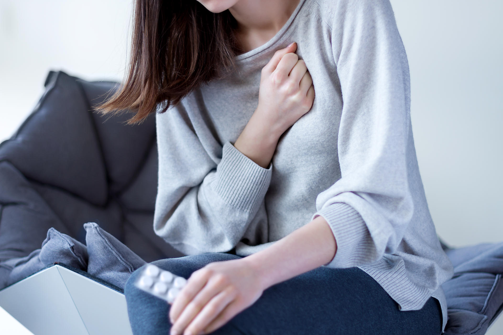 心臓を押さえる人の画像