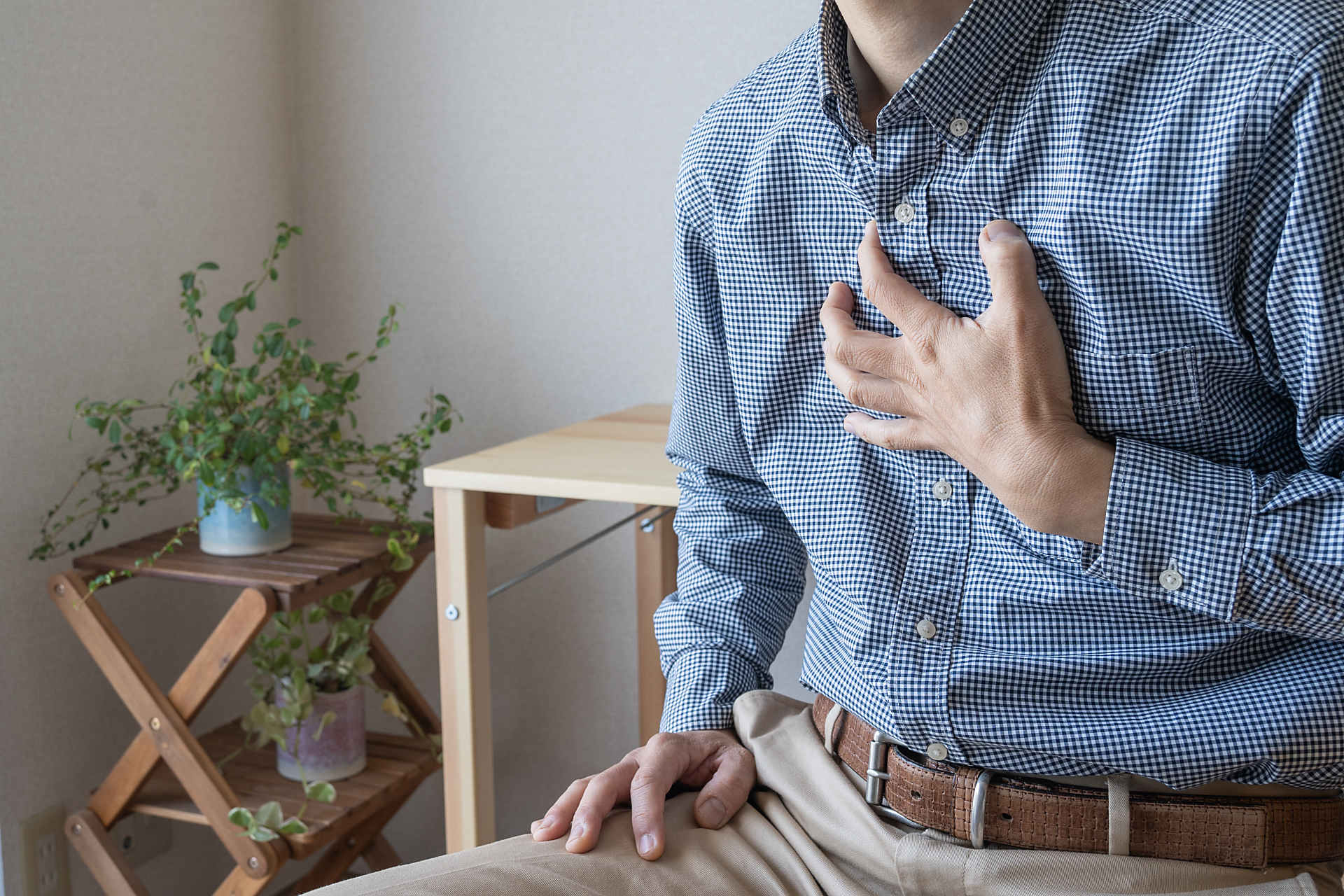 心臓を押さえる人の画像